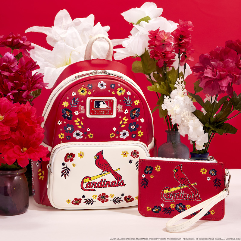 Red and white Loungefly St. Louis Cardinals mini backpack and wristlet clutch against a red and white background and surrounded by red and white flowers